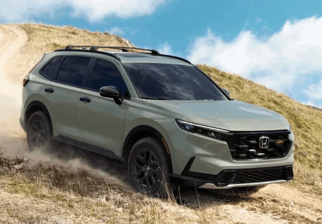 SUV driving on a dirt path in a grassy landscape under a blue sky.
